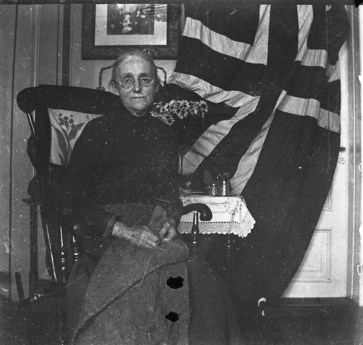 Antonie Olsen på Stilnestnagen, stort flagg bak, 1905?