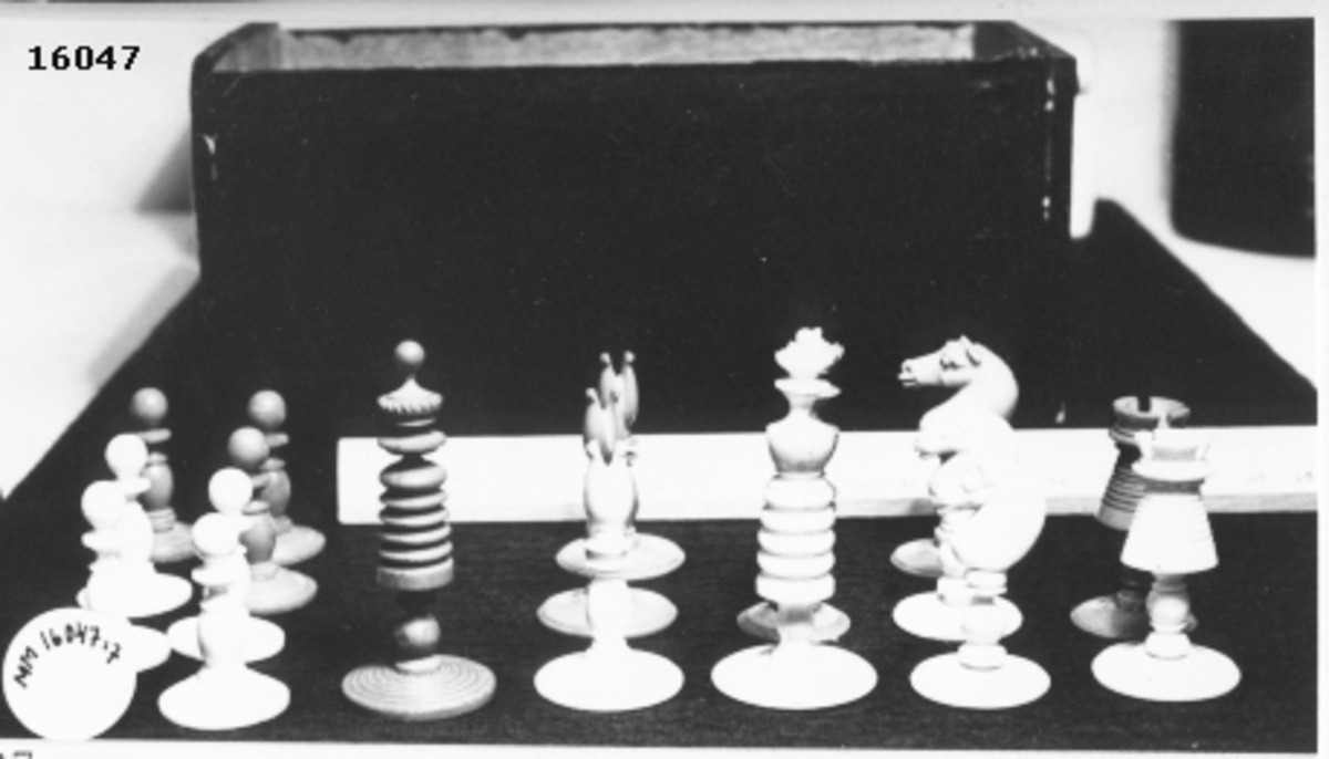Utskuren schackpjäs,röd kung, som står på cirkelrund fot.