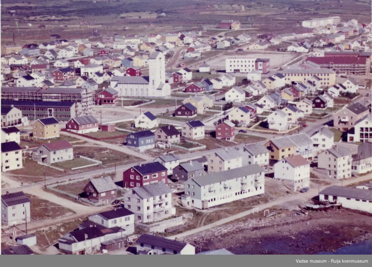 Flyfoto av Vadsø, 1963. Midtbyen sett fra sørvest. Takene i nedre billedkant er husene på Samvirkekaia.