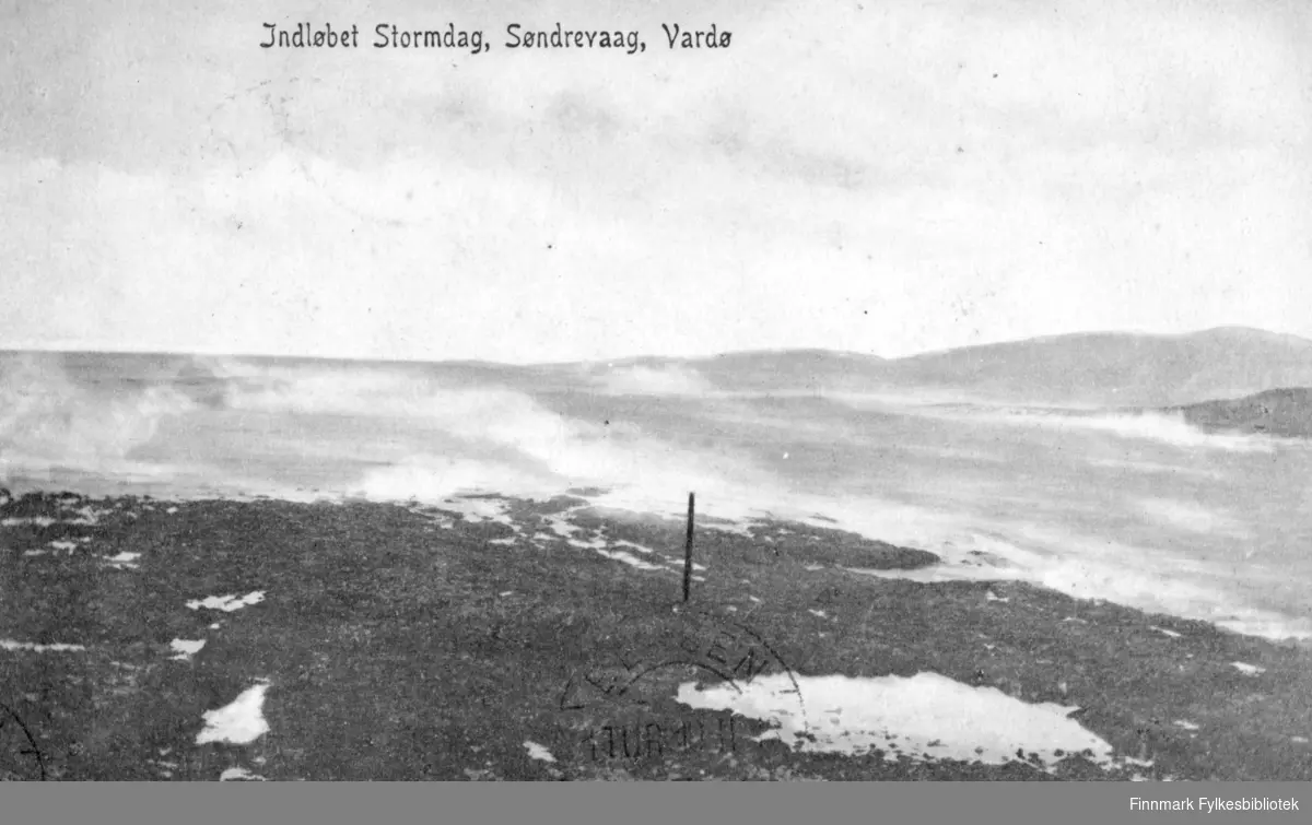 Postkort fra Vardø. På fotografiet ser man innløpet til søndrevåg i Vardø en stormdag. Havet går hvitt og bølgene slår opp mot fjæra. Midt på bilde står det en stolpe