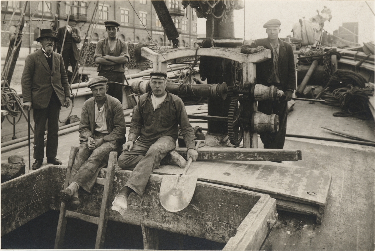 [från fotobeskrivningen:] "Besättningen ombord på galeasen AGIL av Karlskrona i färd med att lossa barlasten i Gävle 1916."