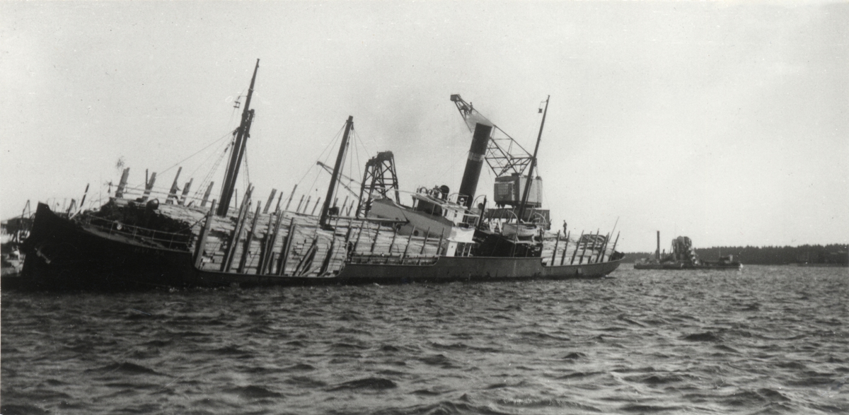 [från fotobeskrivningen:] "Gästrikland, Gävle. Ångfartyget HVIRTA av Halmstad anlöper hamn p g a hård slagsida. Förtöjd vid sydöstra kajen. Fredriksskans den 7.8.1924." [---]