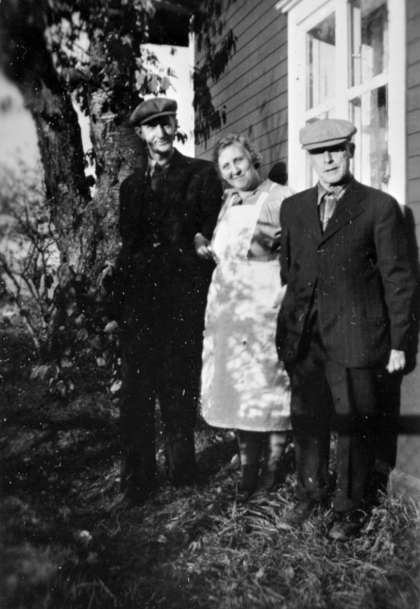 Lars Dæhlin (1899-1966), Netta Dæhlin (1898-1978) og Rudolf Evensen Raknerud (1884-1965) utenfor huset i Roset, Helgøya.