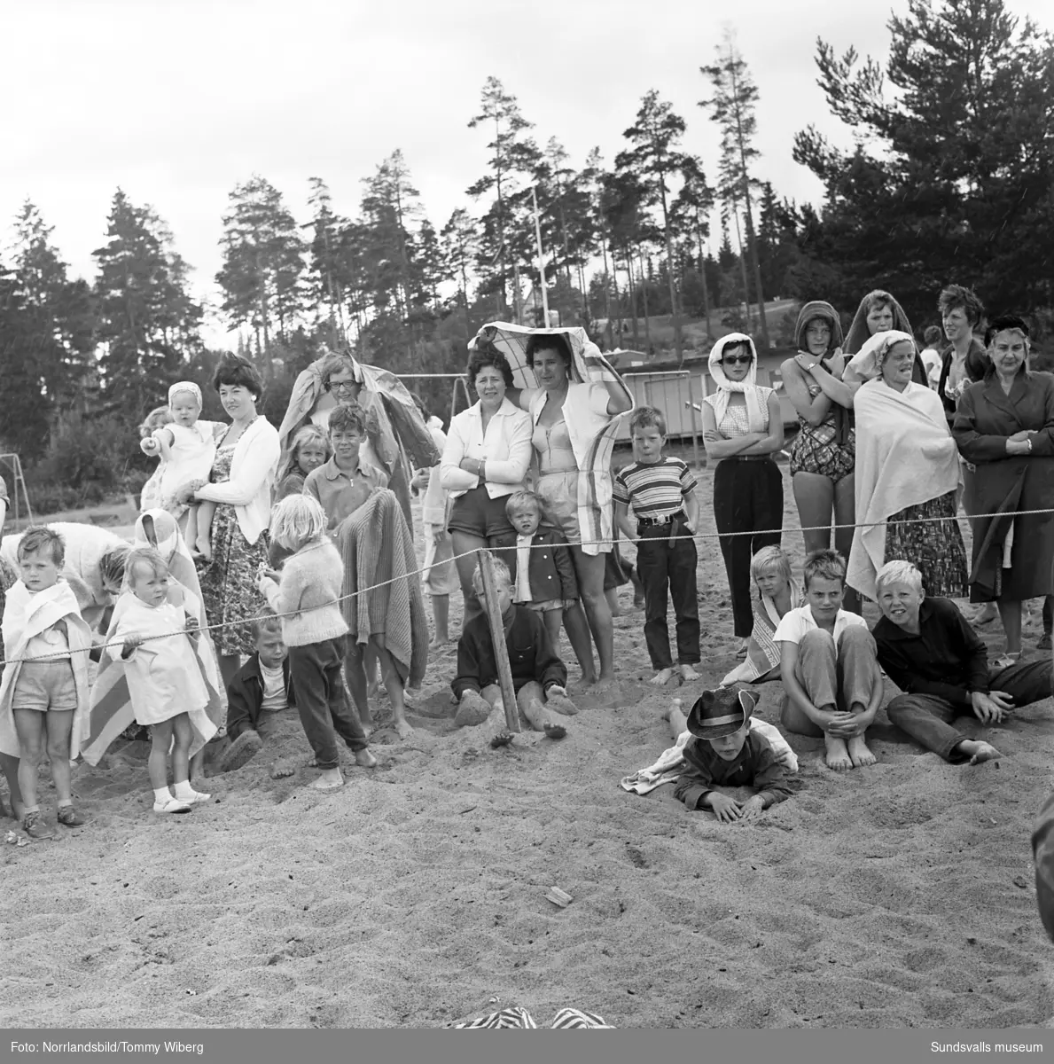 Det ser kallt ut då sommarens simskola vid Fläsian har avslutning. Mannen med megafonen på första bilden är Karl Henrik Rönström, badmästare, polis och senare idrottsintendent i Sundsvall.
