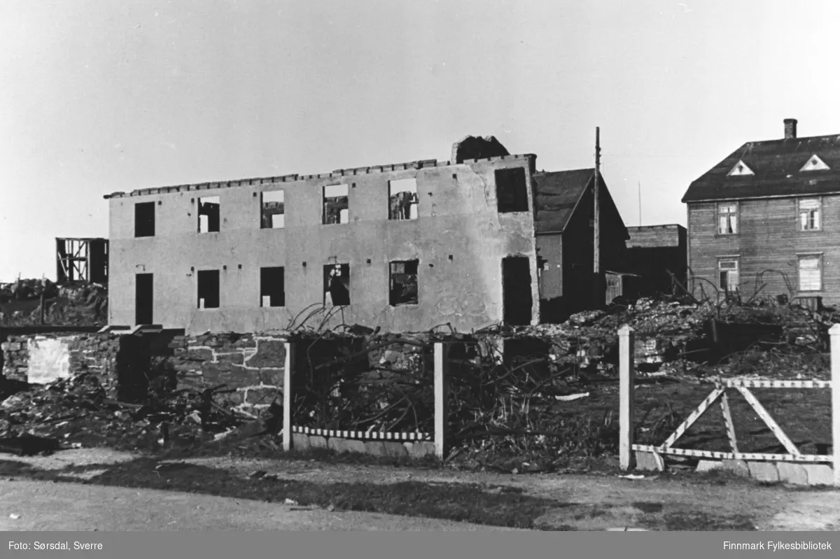 Ruinene av Vardø sykehus som ble bombet i mars 1942. Bak sykehuset står det trebygninger.