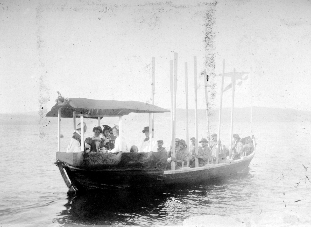 Grefsheim gård, Nes Hedmark. Historisk opptog, båt, Mjøsa, Domkirkeodden, 1911. Robåt, mjøsbåt. "Jomfru Karine kommer med båt fra Grefsheim til Domkirkeodden"