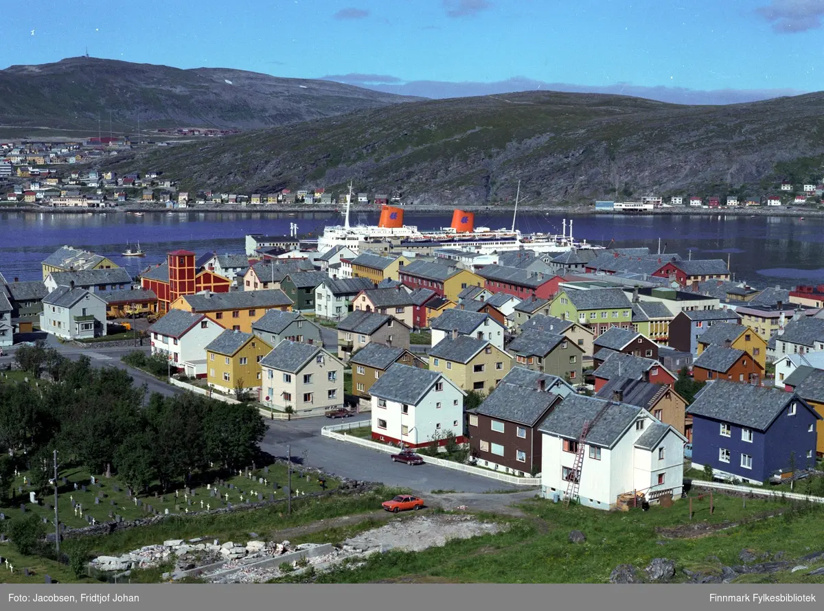 Motiv fra Hammerfest en sommerdag. Bydelen Fuglenes ses på andre siden av havna med Storfjellet bak. Fotografiet er tatt fra Salsiden.