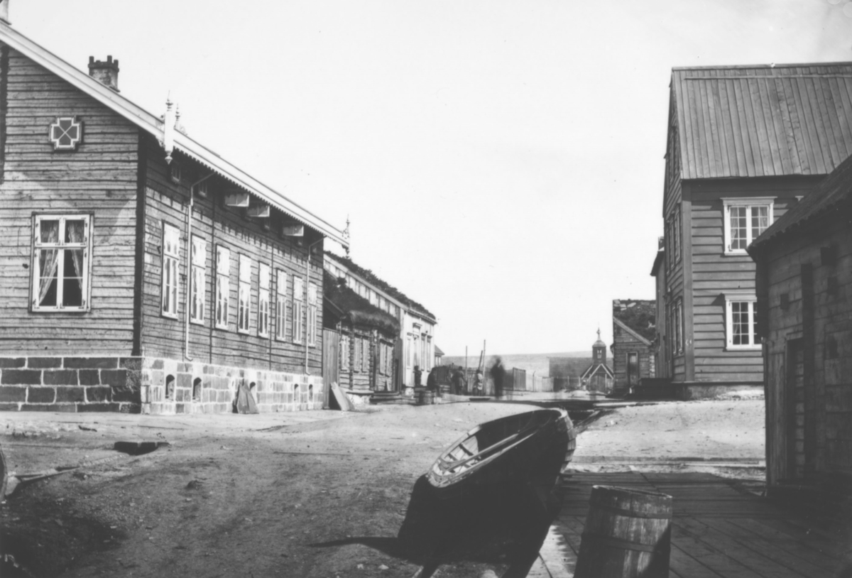 Gateparti fra Vadsø i år ca. 1860. Brodtkorb-gården i Hvistensdahlsgate. (Rådhuset ligger her i dag). Gamlekirka i bakgrunnen, den blev revet i 1864.