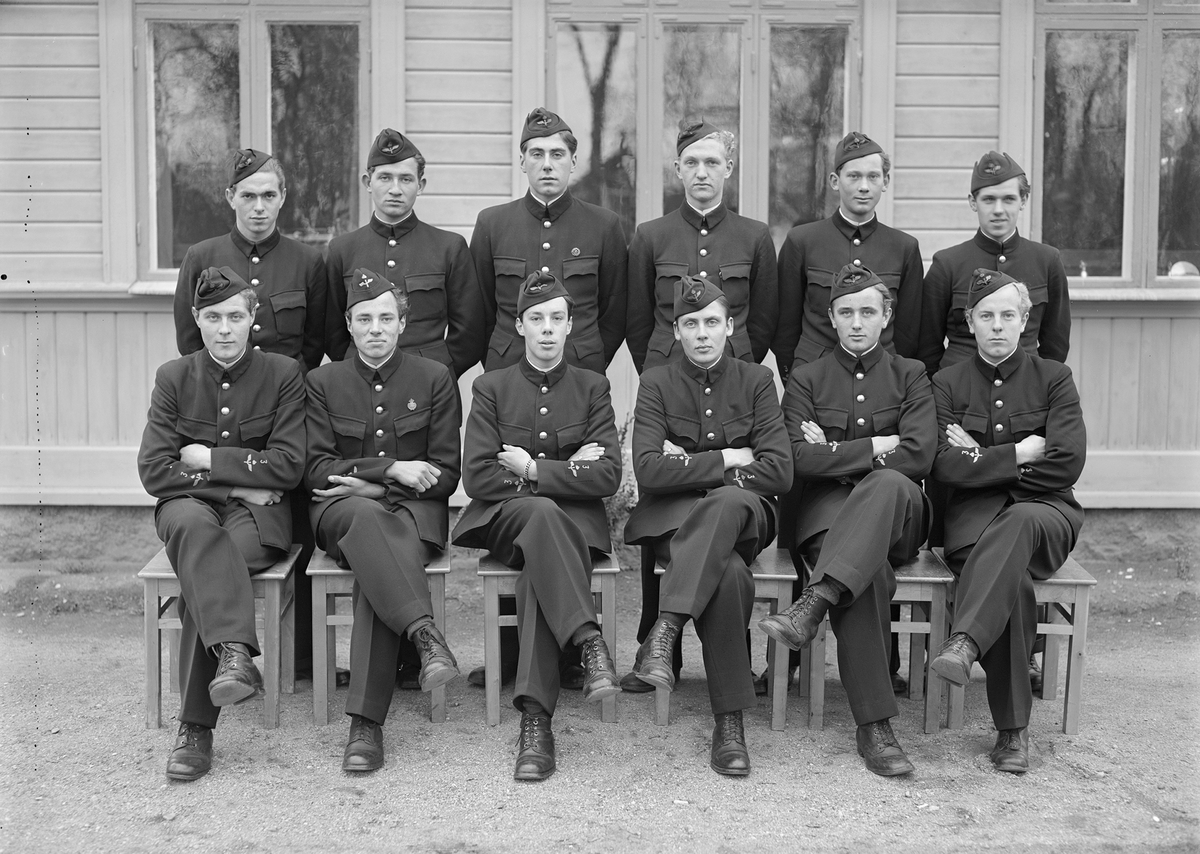 Elever vid korpralskolan på F 3 Östgöta flygflottilj, 1943-1944. Del av grupp. 12 stycken elever. Grupporträtt framför byggnad.