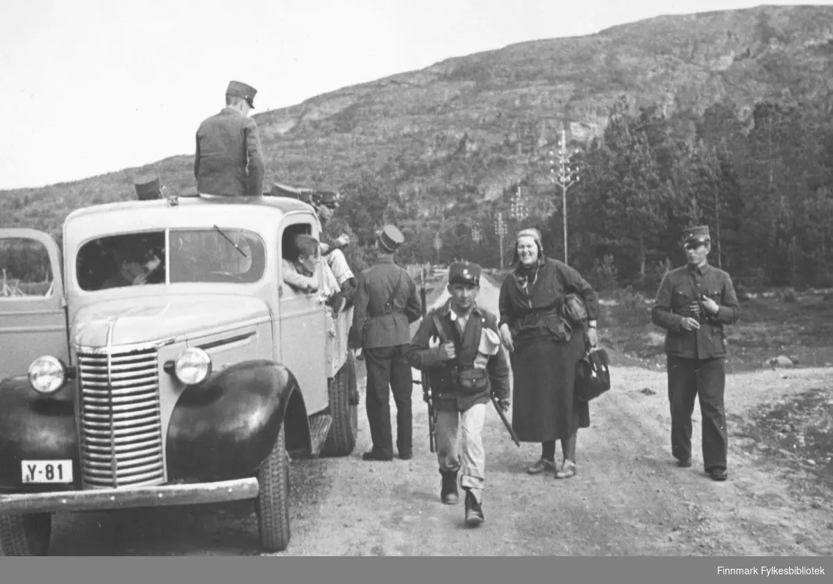 Soldater laster proviant opp på planet til lastebil Y-81. Innskrift i album: "Vi kjører fra matstasjonen". Chevrolet 1939 med norskbygd førerhus.