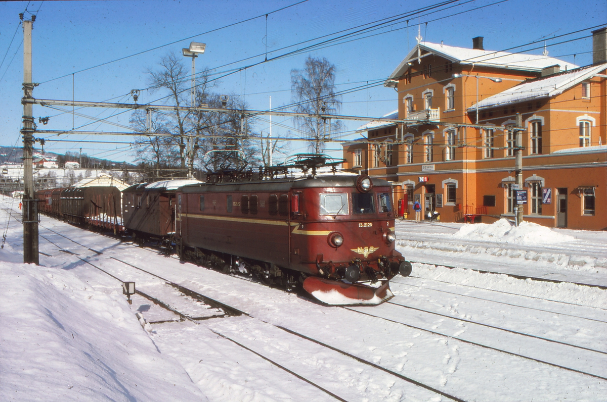 NSB underveisgodstog 5072 Eidsvoll - Lillestrøm i Eidsvoll stasjon med elektrisk lokomotiv El 13 2125 og konduktørvogn. Godstoget var betjent med lokomotivfører, lokomotivførerassistent og overkonduktør ("togfører"), og skiftet på stasjonene underveis. Fotografen tjenestegjorde som lokf.ass. i toget.