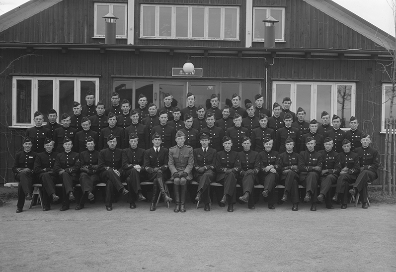 Elever vid korpralskolan på F 3 Östgöta flygflottilj, 1943-1944. Grupporträtt framför byggnad.