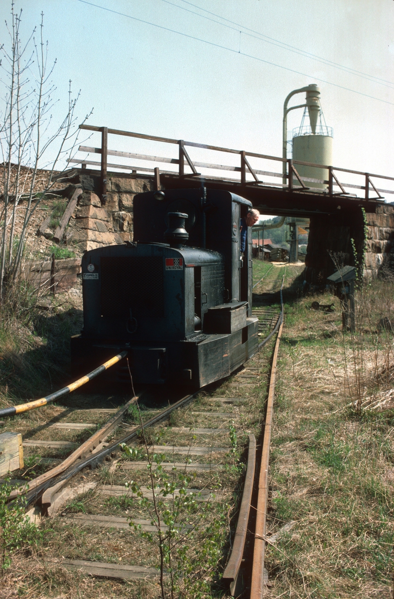 Tog på bruksbanen til Saugbrugs, Halden, (Norske Skog Saugbrugs). Ved undergang under Østfoldbanen. Normalspor. Diesellokomotiv Deutz type OMZ122F, byggenummer 46499 - bygget 1942. Opprinnelig 600mm sporvidde.