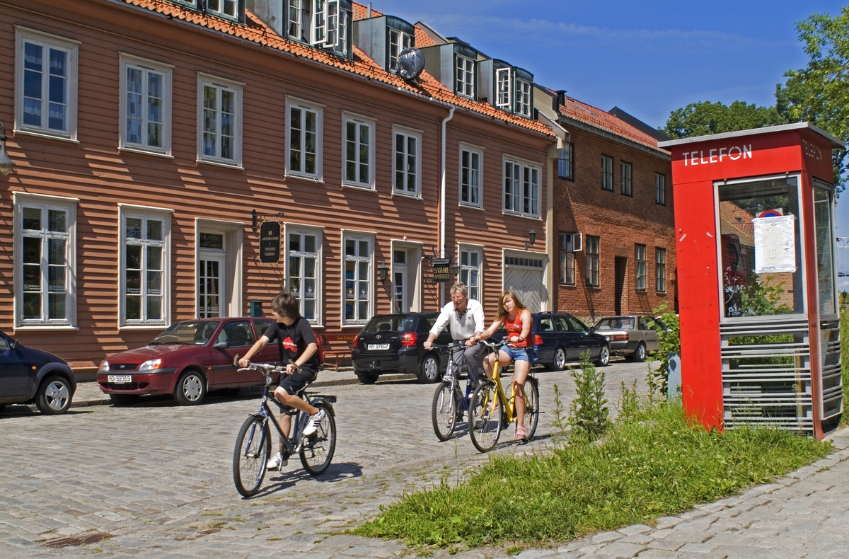 Telefonkiosken står i Gamlebyen i Fredrikstad, og er en av de 100 vernede telefonkioskene i Norge. De røde telefonkioskene ble laget av hovedverkstedet til Telenor (Telegrafverket, Televerket). Målene er så å si uforandret. 
Vi har dessverre ikke hatt kapasitet til å gjøre grundige mål av hver enkelt kiosk som er vernet. 
Blant annet er vekten og høyden på døra endret fra tegningene til hovedverkstedet fra 1933.
Målene fra 1933 var:
Høyde 2500 mm + sokkel på ca 70 mm
Grunnflate 1000x1000 mm.
Vekt 850 kg.
Mange av oss har minner knyttet til den lille røde bygningen. Historien om telefonkiosken er på mange måter historien om oss.  Derfor ble 100 av de røde telefonkioskene rundt om i landet vernet i 1997. Dette er en av dem.