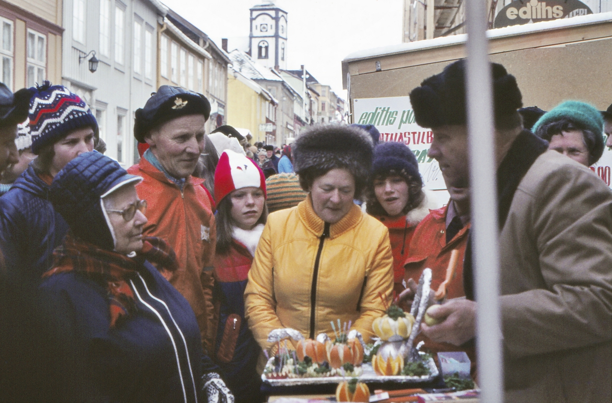 Rørosmartnan 1974. Selger av frukt- og grønnsakkutter demonstrerer produktet for interesserte tilhørere i Kjerkgata.