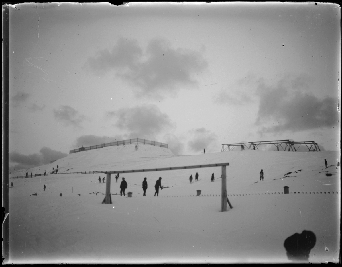 Vinter i Vardø. Fotografen har stått i området rundt prestegården eller ved skolegårdsgjerdet og fotografert opp mot Klondyke