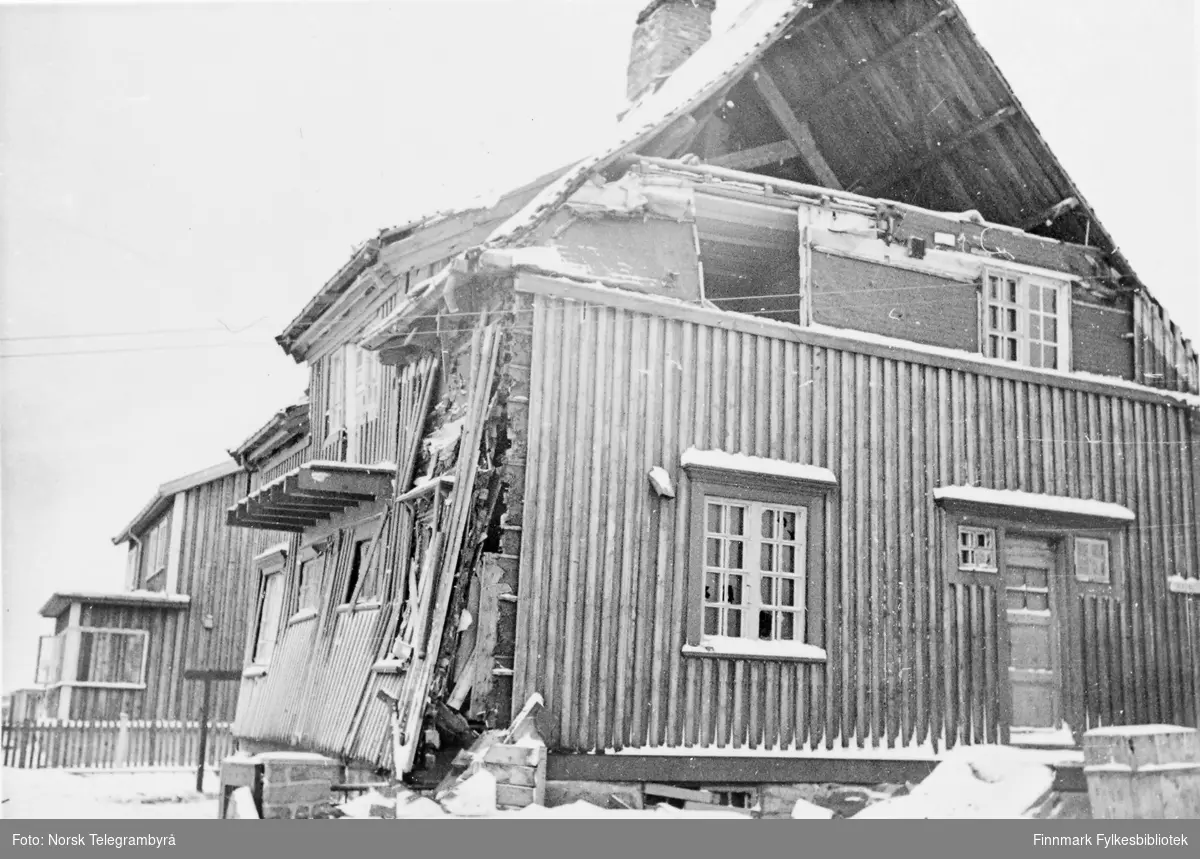 'Bombeskadet hus i Vadsø. (Ingeniør Hofseths hus, senere skole-direktørbolig.)' Vi ser her et delvis skadet hus. Ingeniør HaraldHofseth ble født 1892 i Talvik. I 1920 ble han ansatt ved FinnmarkVeivesen hvor han var til sin død i 1951, med et unntak 1945-1947 dahan var ved Finnmarkskontoret.