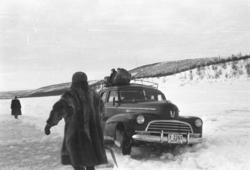 En drosje, Chevrolet 1946 mod,  har kjørt seg fast på isveie
