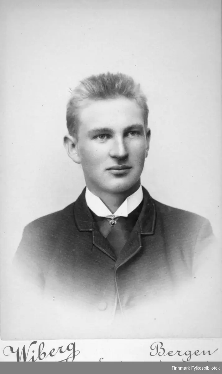 Portrett av en ung mann. Han har mørk jakke på seg og den hvite skjortekragen ses rundt halsen hans. Portrettet er tatt hos Halfdan Wiberg i Bergen.