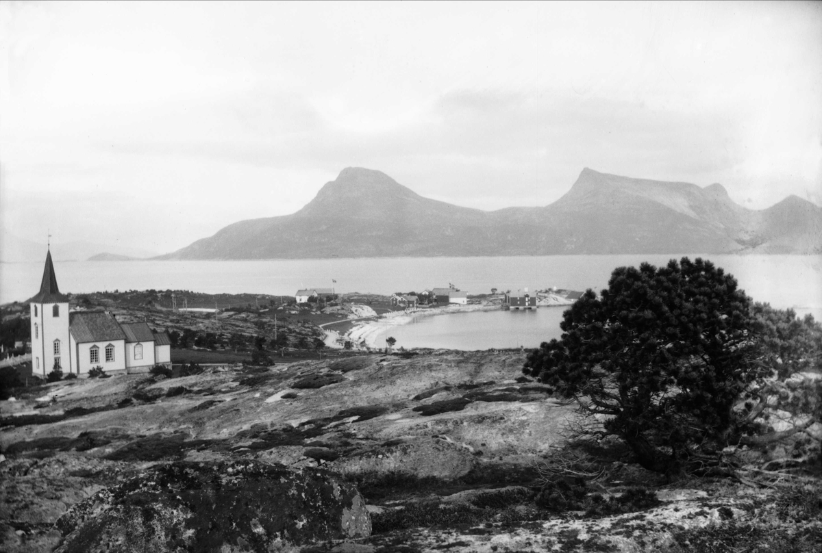 Landskapsbilde fra Korsnes. Kirka til venstre, bebyggelse og fjell i bakgrunnen.
