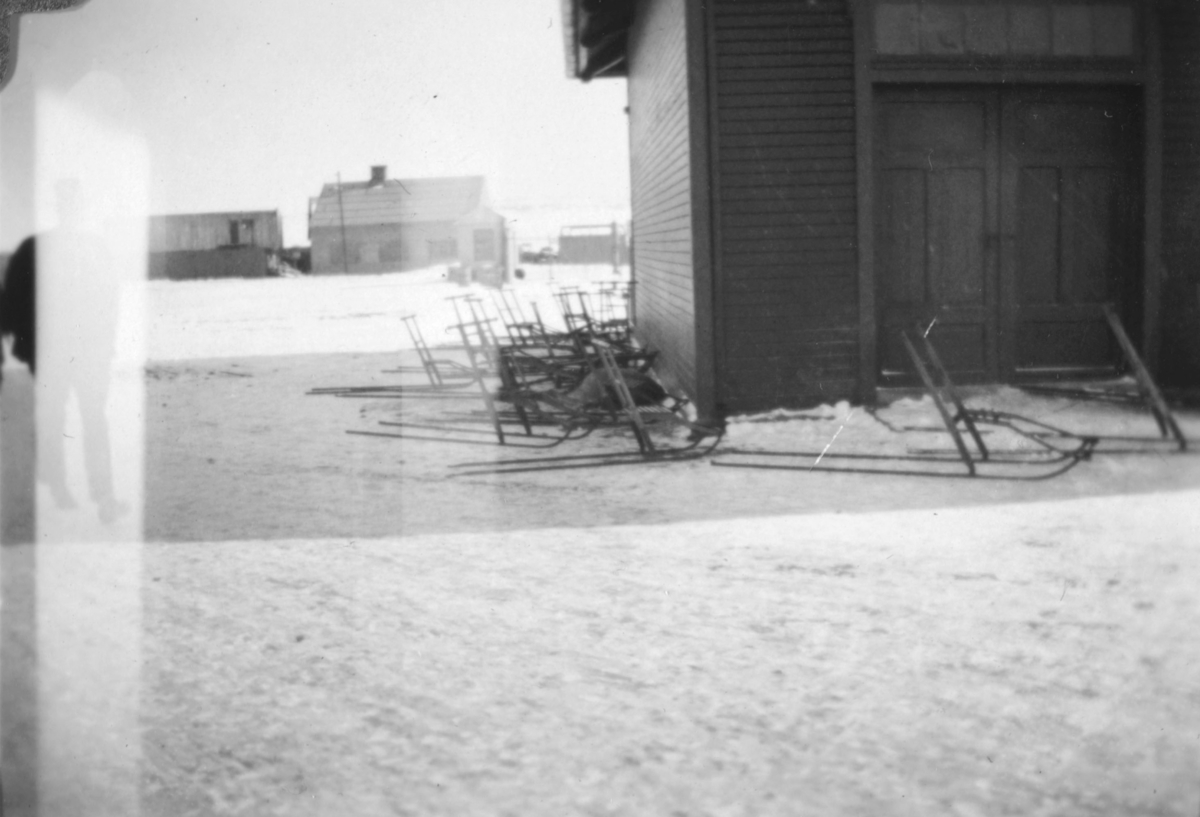 Stemningsbilde nede ved dampskipskaia i Vadsø. Det står mange sparker parkert ved bygningen. Hurtigruten har antakelig anløp på tidspunktet da bildet ble tatt