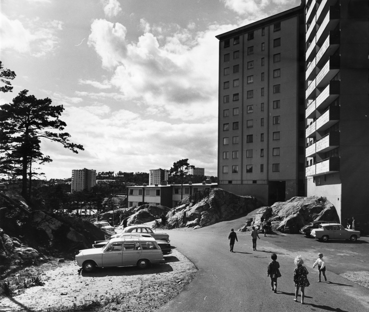 Foto av drabantbyen Tinnheia i Kristiansand. Barn leker utenfor høyblokk.