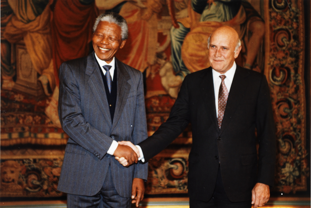 Nelon Mandela og Frederik Willem de Klerk tar hverandre i hendene i forbindelse med tildelingen av Nobels fredspris i 1993. .