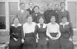 Portrett, elleve personer samlet i husveggen, landbruksskole