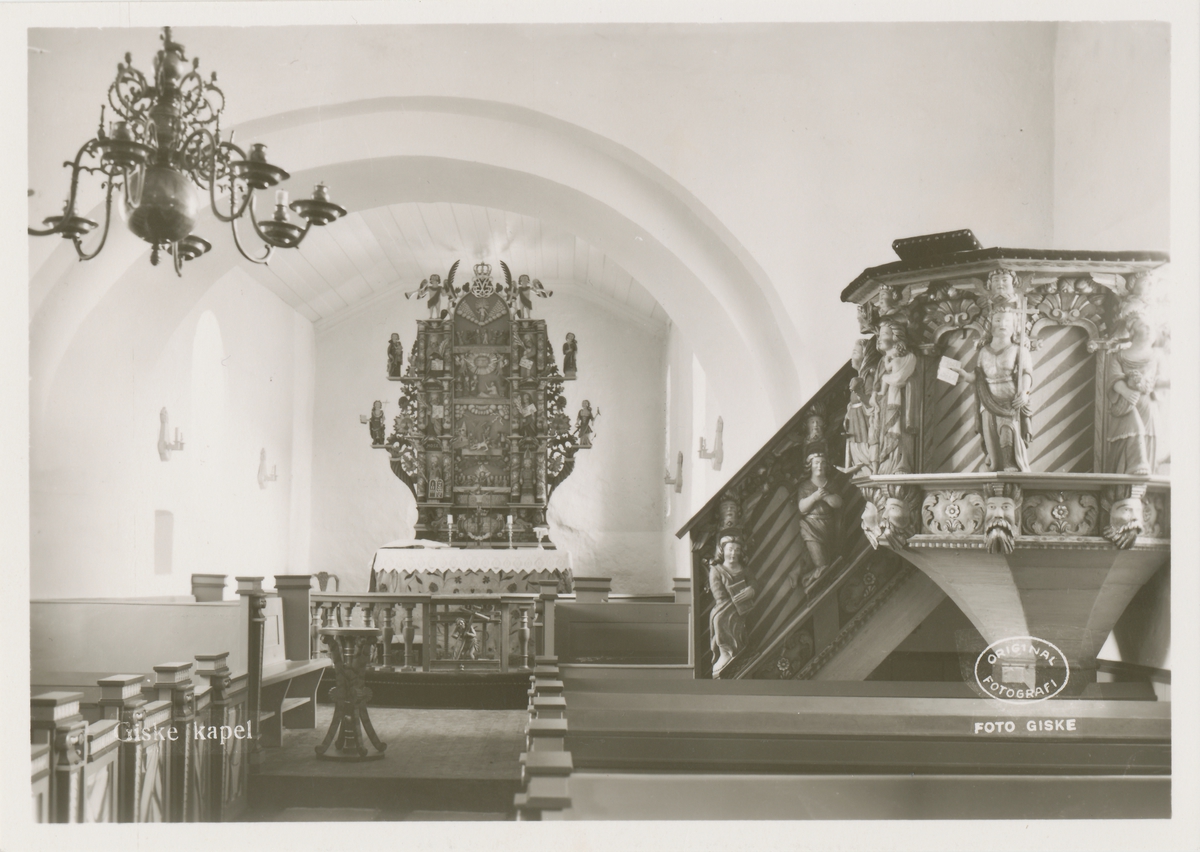 Interiørfotografi av preikestol, altertavle og benker i Giske kirke.