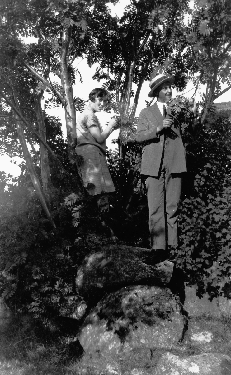 Kvinne og mann, fotografert ute ved noen busker.