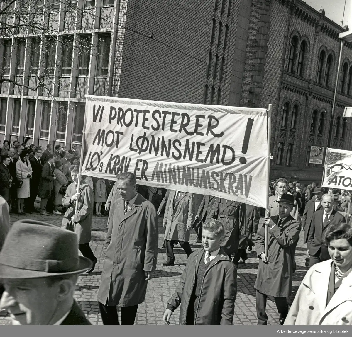 1. mai 1964 i Oslo.Demonstrasjonstoget i Karl Johans gate.Parole: Vi protesterer mot lønnsnemd!.LO's krav er minimumskrav.