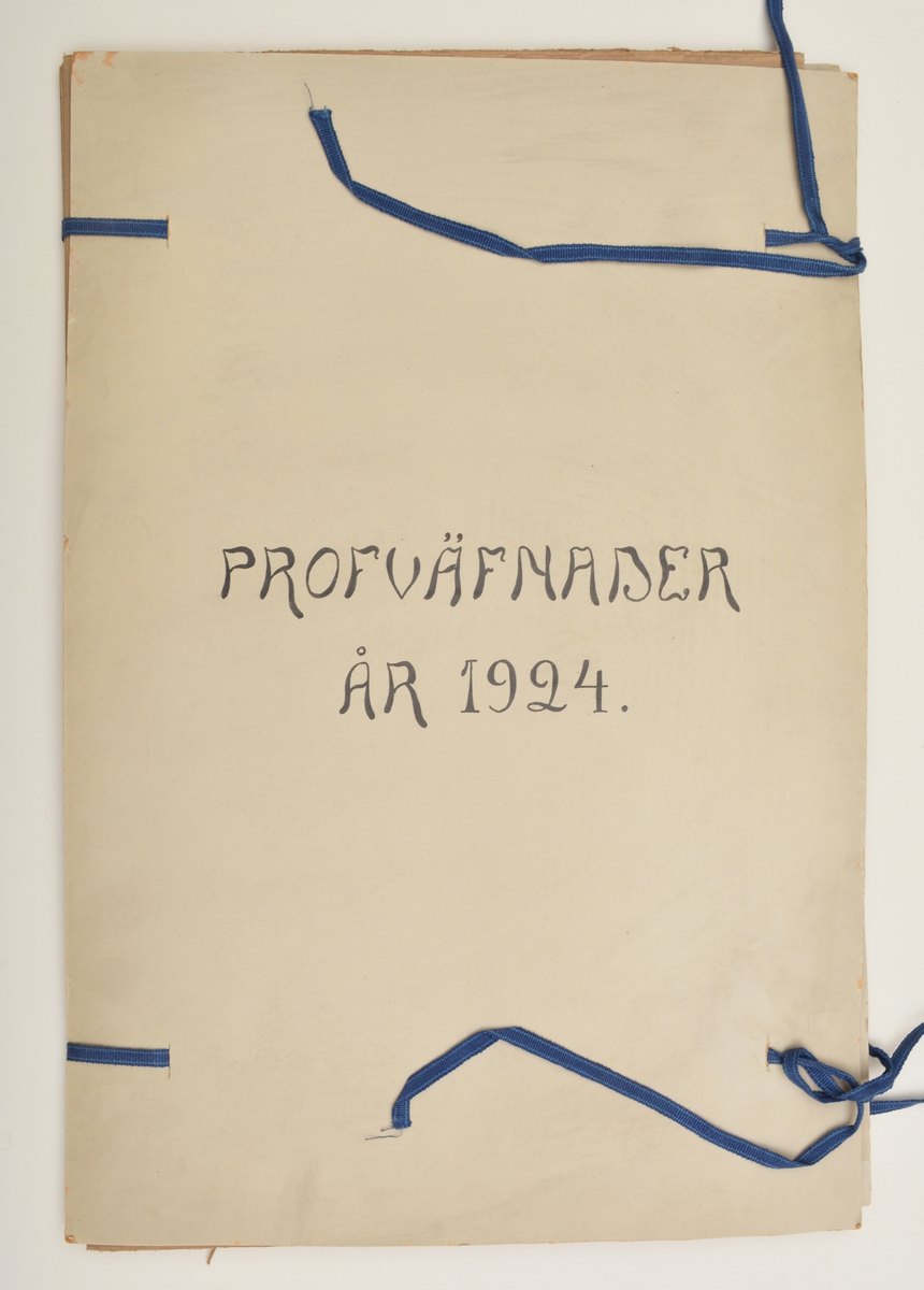 Stor pappersmapp med lösa blad med påklistrade tygprover. Pärmarna är av en annan papperskvalité än papperna innuti. Pärmarna hålls ihop med ett par långa, handvävda band.
Text på framsidan; "Väfprofer År 1924".