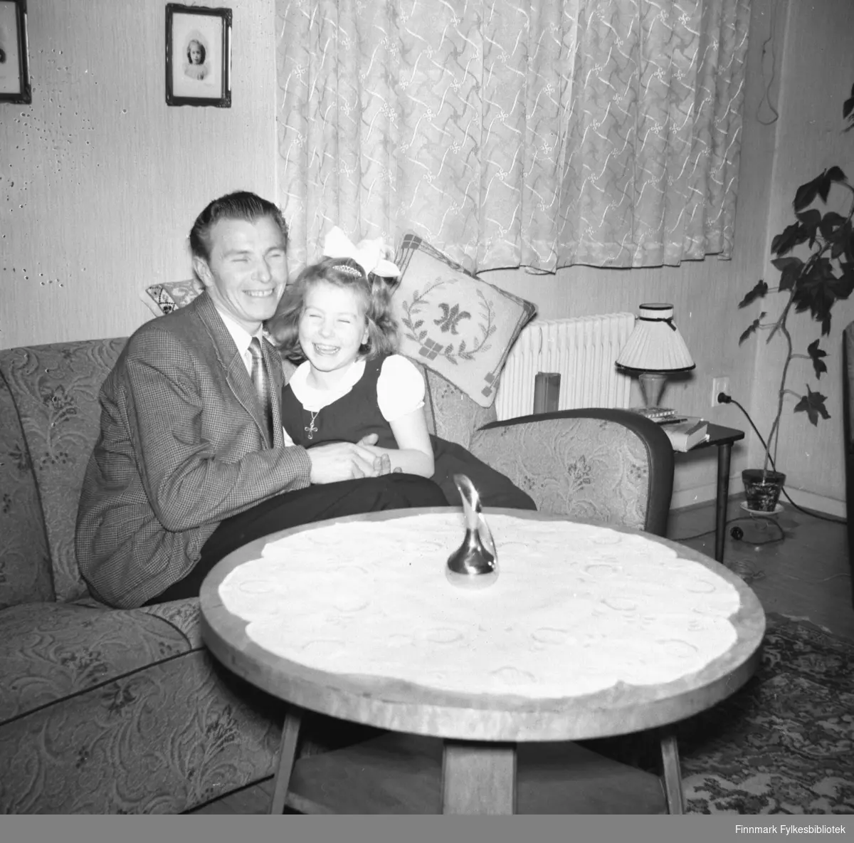Far med datteren sin (Eino og Turid Lillian) sitter i sofaen og ler