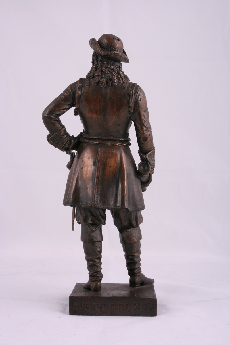 Kopi av Bissen sin statue av Tordenskjold. Statuen har et løst sverd på venstre side . Venstre hånd hviler på hofta og han har en kikkert i høyre hånd. Figuren har på seg frakk, støvler og en rund hatt, den har også  en medalje rundt halsen.