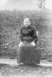 Portrett, eldre kvinne sitter på stol utendørs, Ågot sitter 