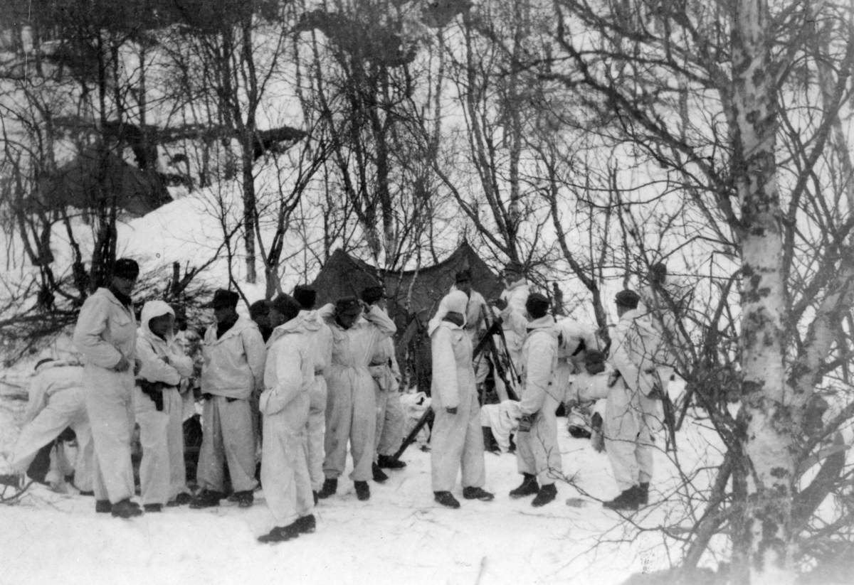 Norske soldater i vinterkamuflasje. Snø og telt i bakgrunnen.
