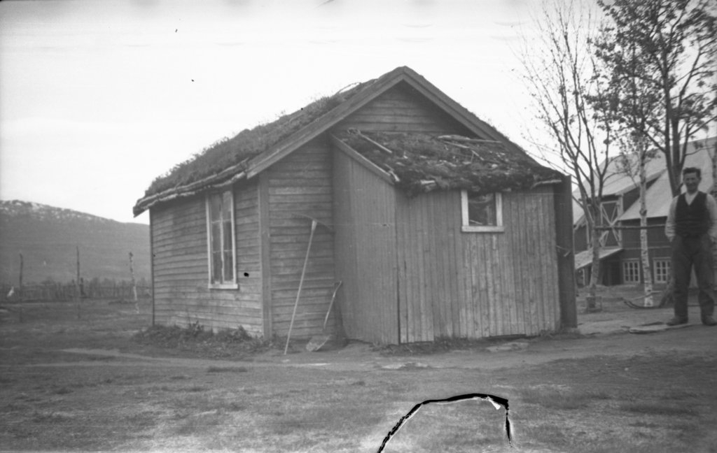 John Peder Andersen(54) ved siden av bolighuset sitt på Dalsletta i Gratangen 1943. Det lille huset var delt i to rom. I bislaget var det ikke plass til stort mer enn vassbøttene. I 1944 flytta familien inn i nytt og større hus på andre side av veien.