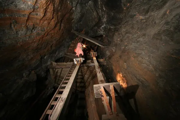 Mann som demonstrerer bruken av mannskapsheisen i gruva.