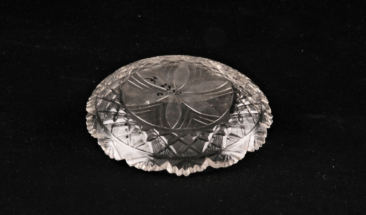 Karaffel med propp og skål av slepet krystall. Karaffel (a) har tre skiver på halsen. og er dekorert med vifteform og stjerner på magen. Glasspropp (b) dekorert med stråler. Skålen (c) dekorert med en seksbladsrose.