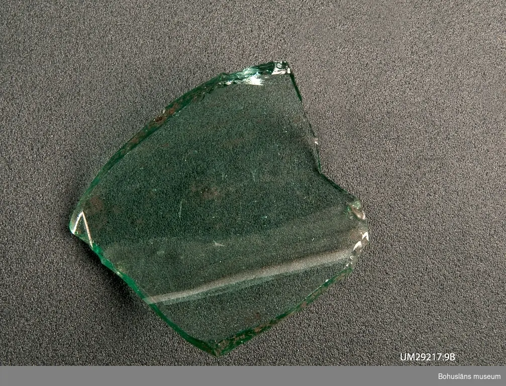 Fragment av flaska, klart glas. I Ö delen av stengolvets S avslutningskant