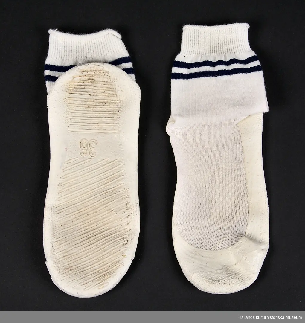 Vita resårstickad sockor i bomull, belagda med sula av vit plast. Dekorerade med blå border.

Storlek 36.