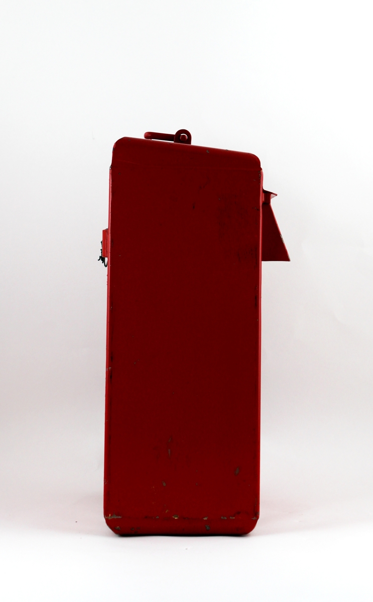 Brevlåda i rödmålad järnplåt från Portugal. Med lockförsett brevinkast på fronten. Ovantill är ett handtag placerat. Brevlådan tömmes genom en lucka på höger kortsida. Två nycklar finns.
Fastsättningsanordning och skruvar förvaras i brevlådan.