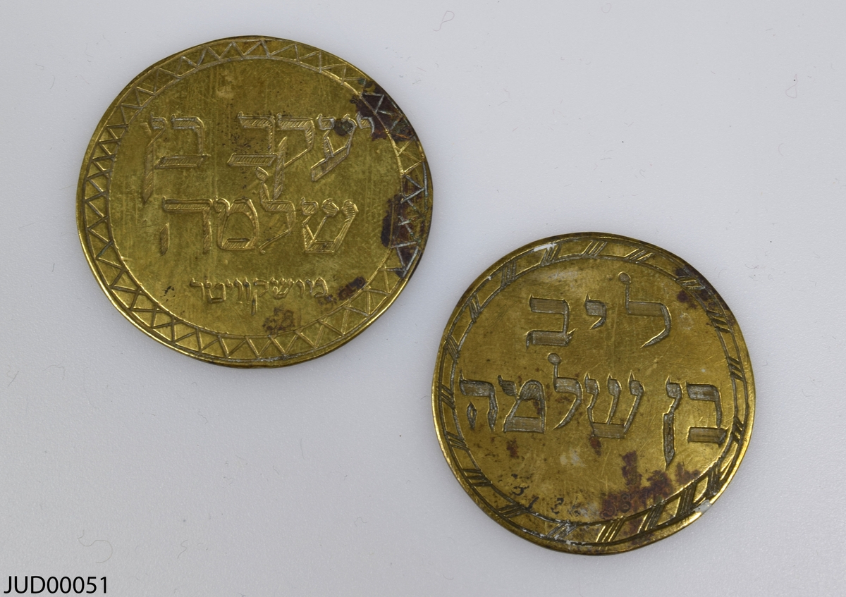 Två stycken bronsmynt. Det ena myntet är dekorerad med en vas samt hebreisk text, medan det andra myntet endast är dekorerat med hebreisk text. Båda är mycket tunna.