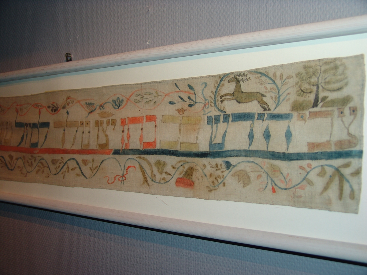 Wimpel tillverkade av linneduk, med vattenfärgsdekorationer i form av figurer, blommor, djur och hebreisk text.