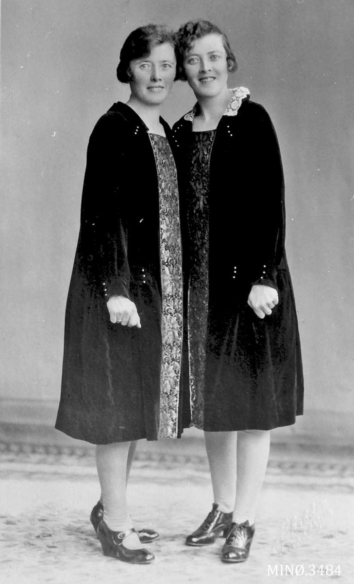 To kvinner, leggside jakker, kortere kjoler