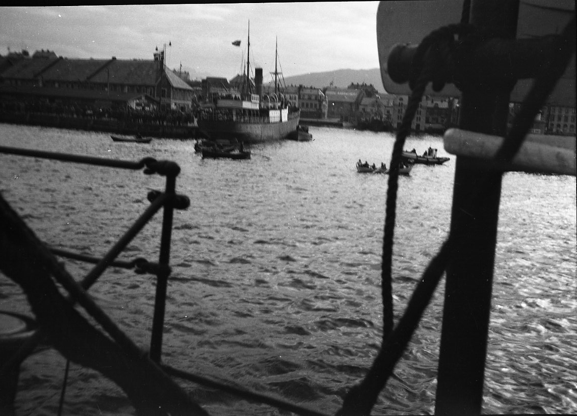 Sannolikt foto från kanonbåten HMS Svensksund mot okänd hamn med flera små båtar och ett fartyg.