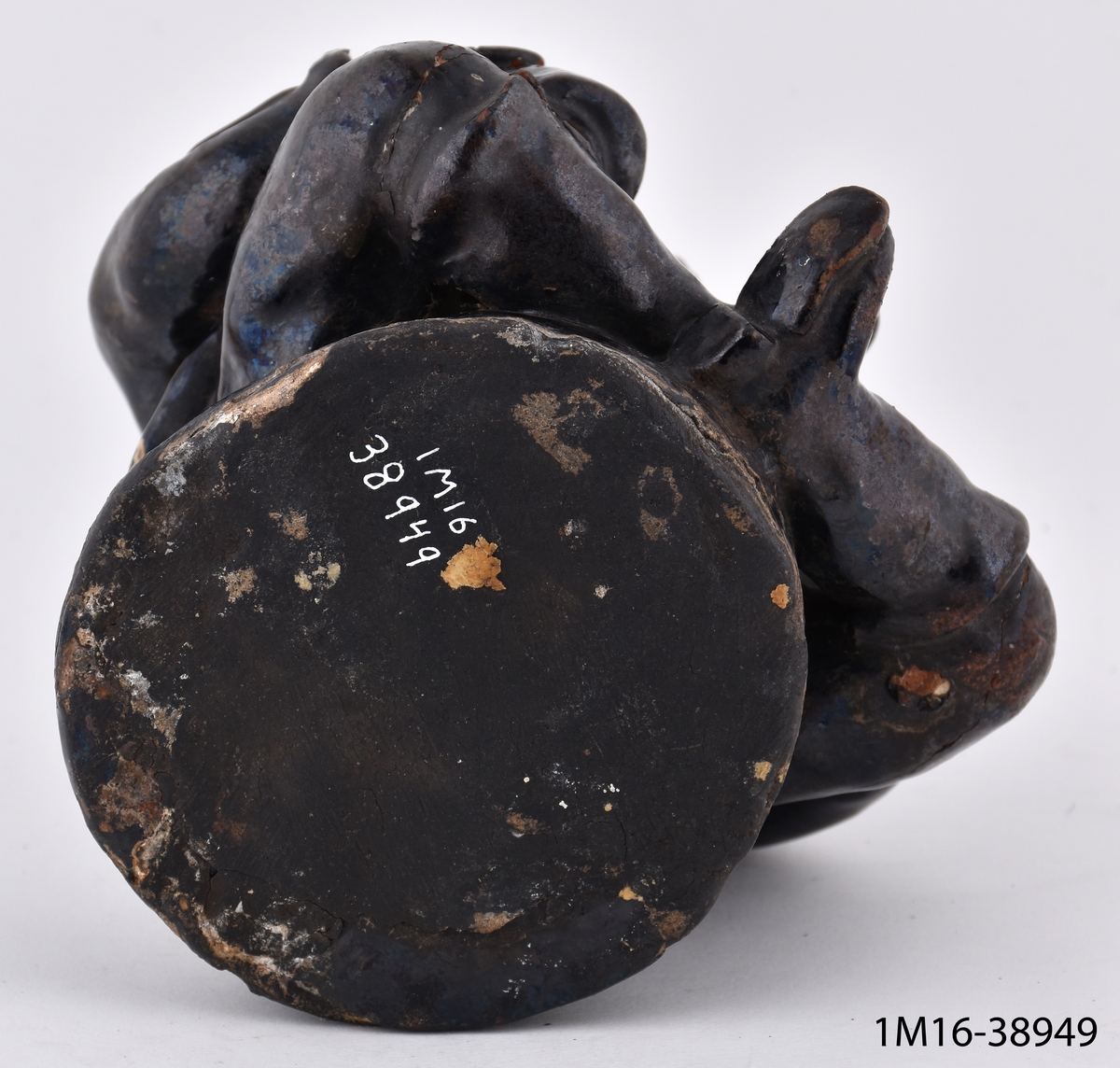 Flaska av svart lergods i form av en rökande gubbe.