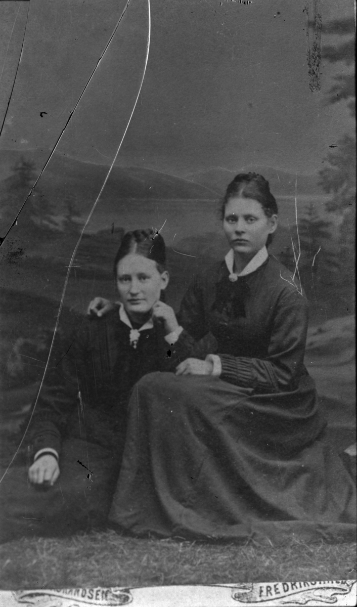 Portrett av to damer i studio med fjelllandskap som bakgrunn