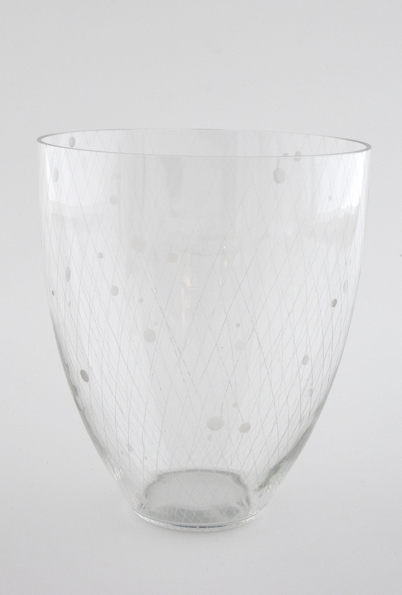 Konisk vase i tynt, klart glass.  Korpus er dekorert med et gravert rutenett, hvor det tidvis forekommer graverte sirkler i ulik størrelse.