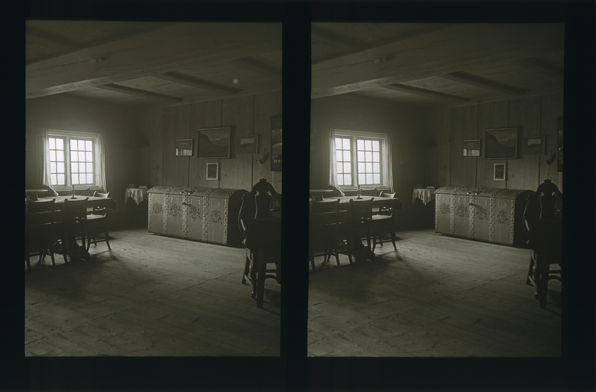 Harildstad gård. Stue møblert med spisebord og kiste. Malerier på veggene. Tilhører Arkitekt Hans Grendahls samling av stereobilder.
